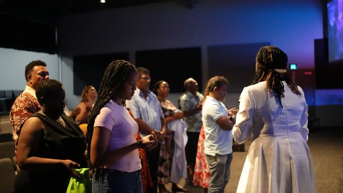 Dr. Imaobong Odutola praying with believers